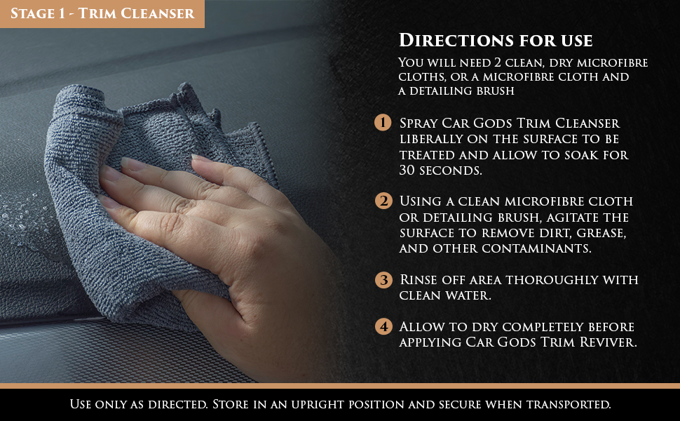 Image shows a car dashboard being cleaned with Car Gods Trim Cleanser and a grey microfibre cloth. Text: Use only as directed on the bottle. Store in an upright position and secure when transported.