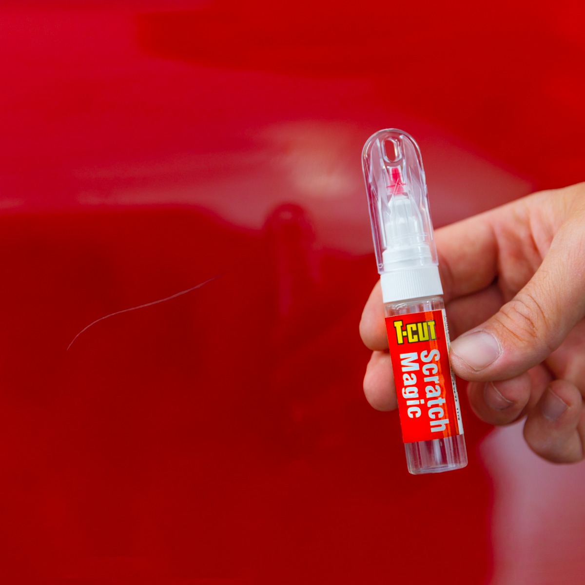 T-Cut scratch magic pen next to red car body panel